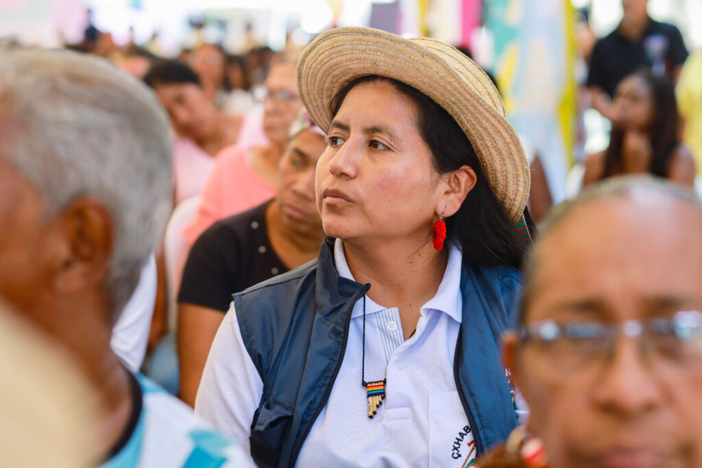 Periodista indígena escuchando un discurso en el Festival Por la Vida